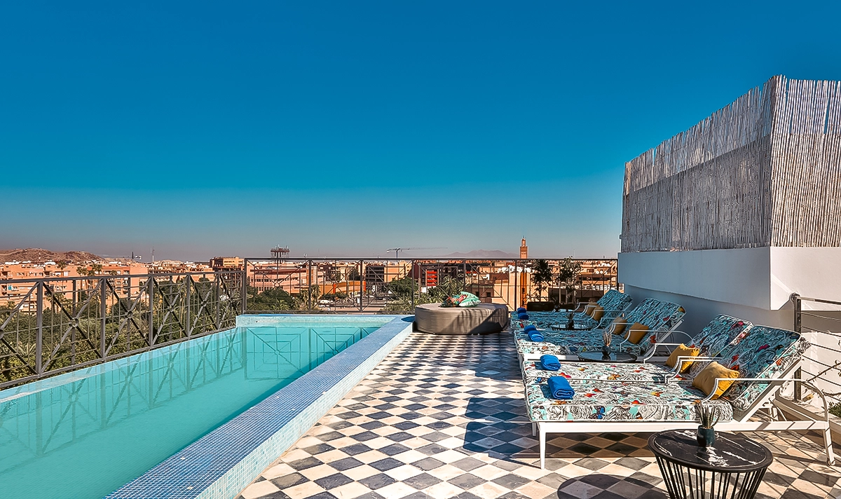 Piscina del rooftop del hotel 2Ciels con vistas al barrio de Gueliz y un minarete de Marrakech