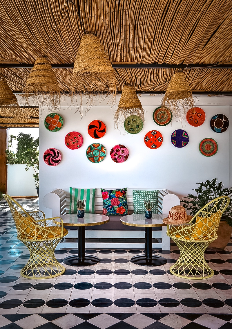 Terraza café del hotel 2Ciels Marrakech con cestas de artesanía marroquí en la pared