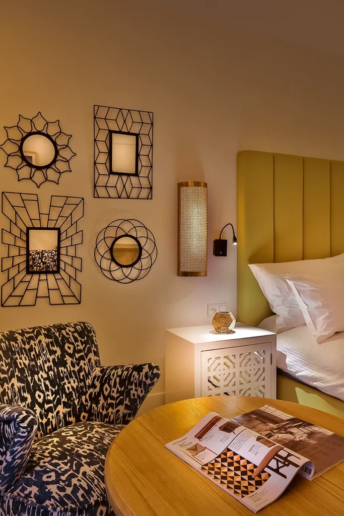 Habitación Deluxe del hotel 2Ciels Marrakech con cabecero mostaza y butaca ikat