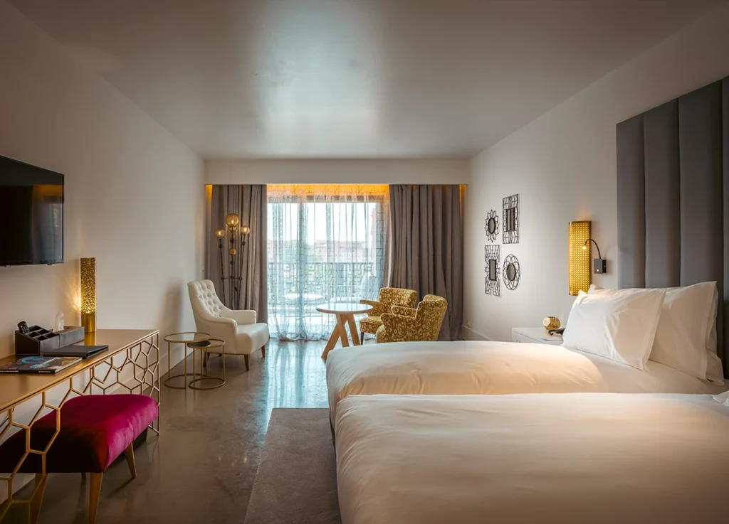 Habitación Deluxe del hotel 2Ciels Marrakech con camas individuales y puertas al balcón