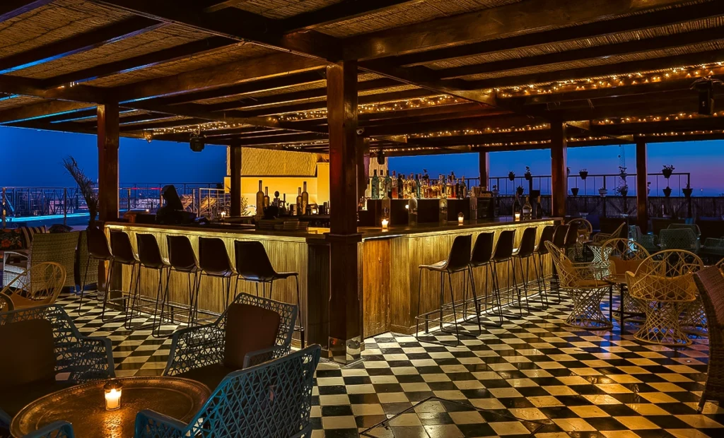 Barra de Lola SkyLounge del hotel 2Ciels Marrakech a la hora azul con guirnaldas de luces