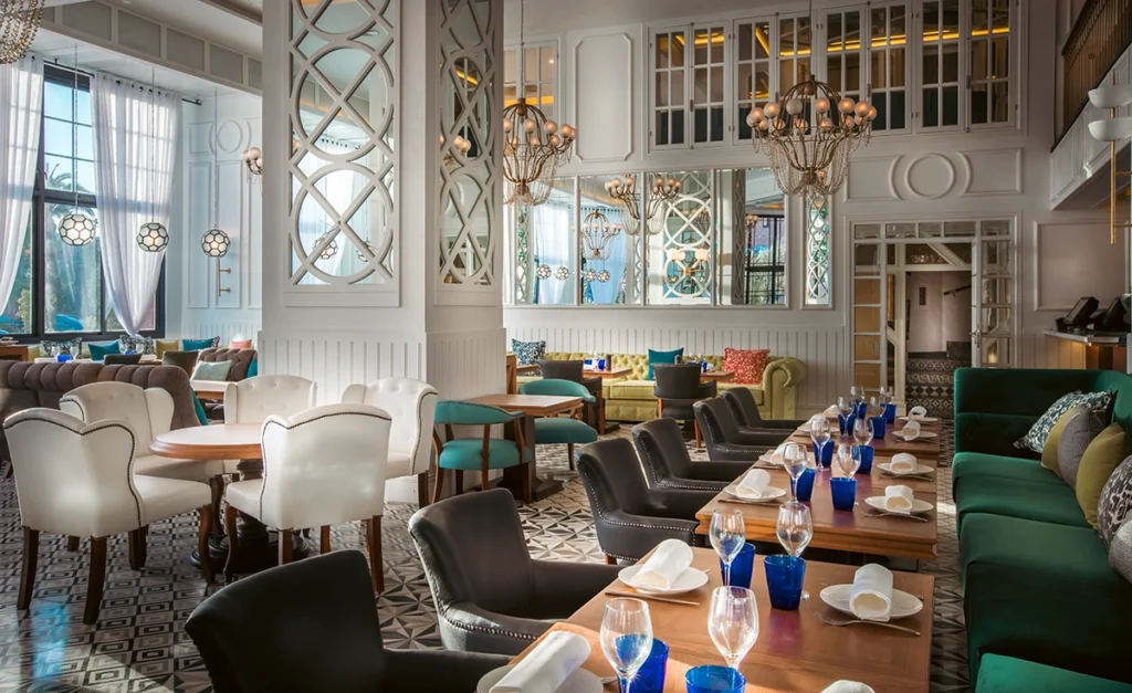 Restaurante Patron de la Mer del hotel 2Ciels Marrakech con banqueta verde y paneles de espejo