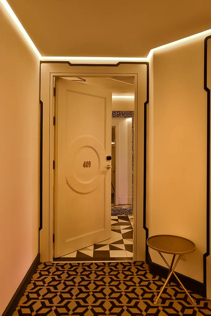 Puerta abierta de una habitación del hotel 2Ciels Marrakech con el recibidor de azulejo