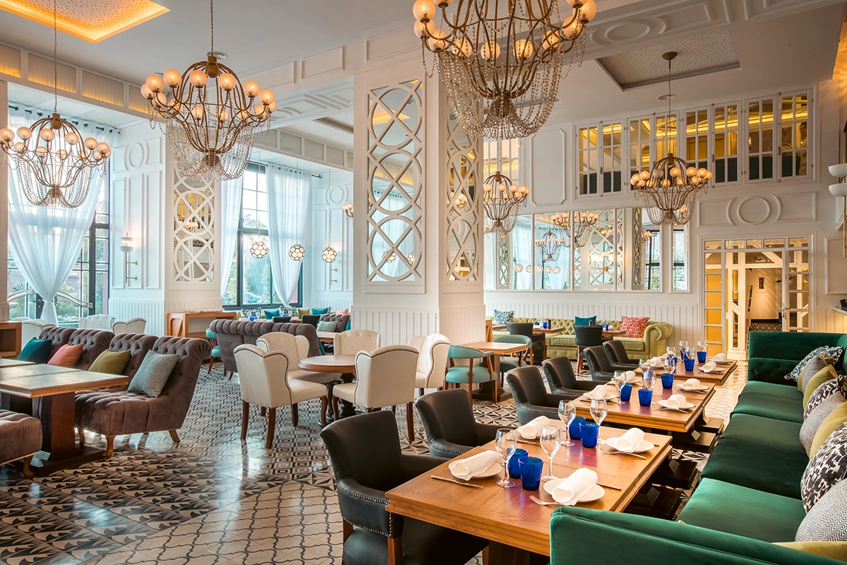 Comedor del restaurante del hotel 2Ciels Marrakech con lámparas de cuentas y banquetas verdes