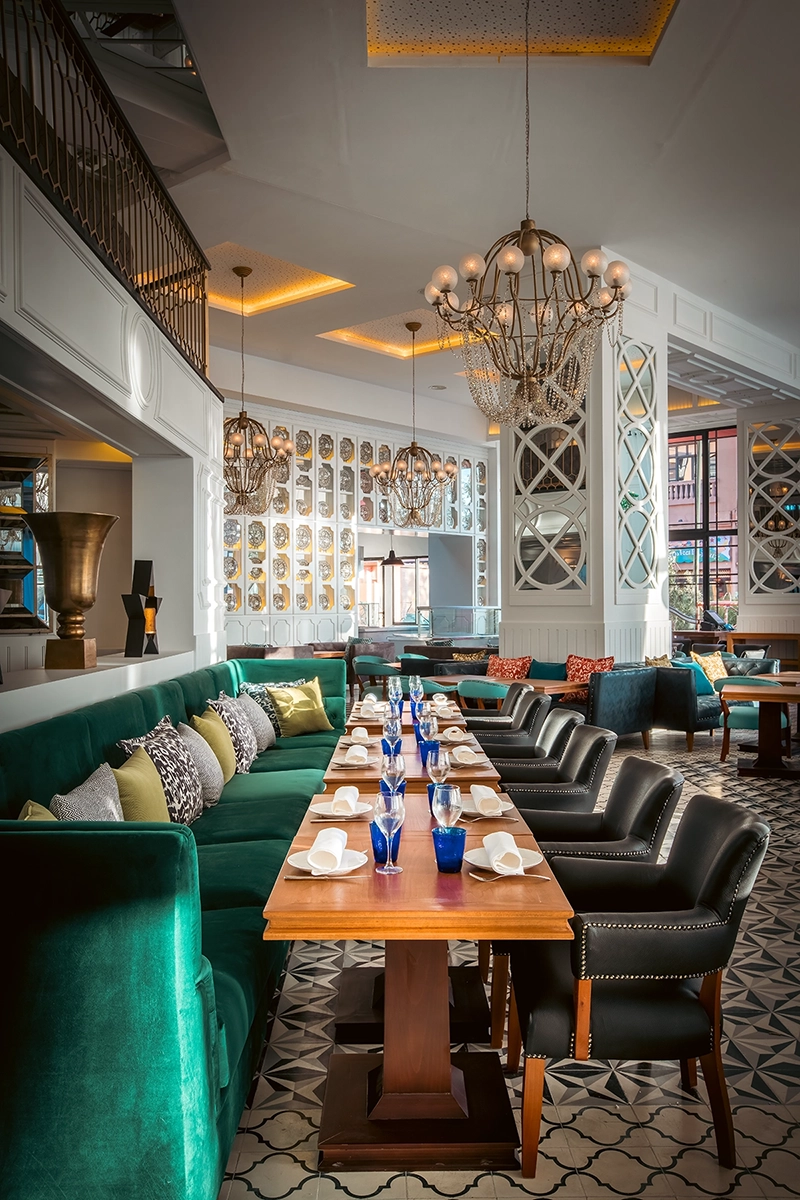 Sala del restaurante Patron de la Mer del hotel 2Ciels Marrakech con banqueta de terciopelo verde