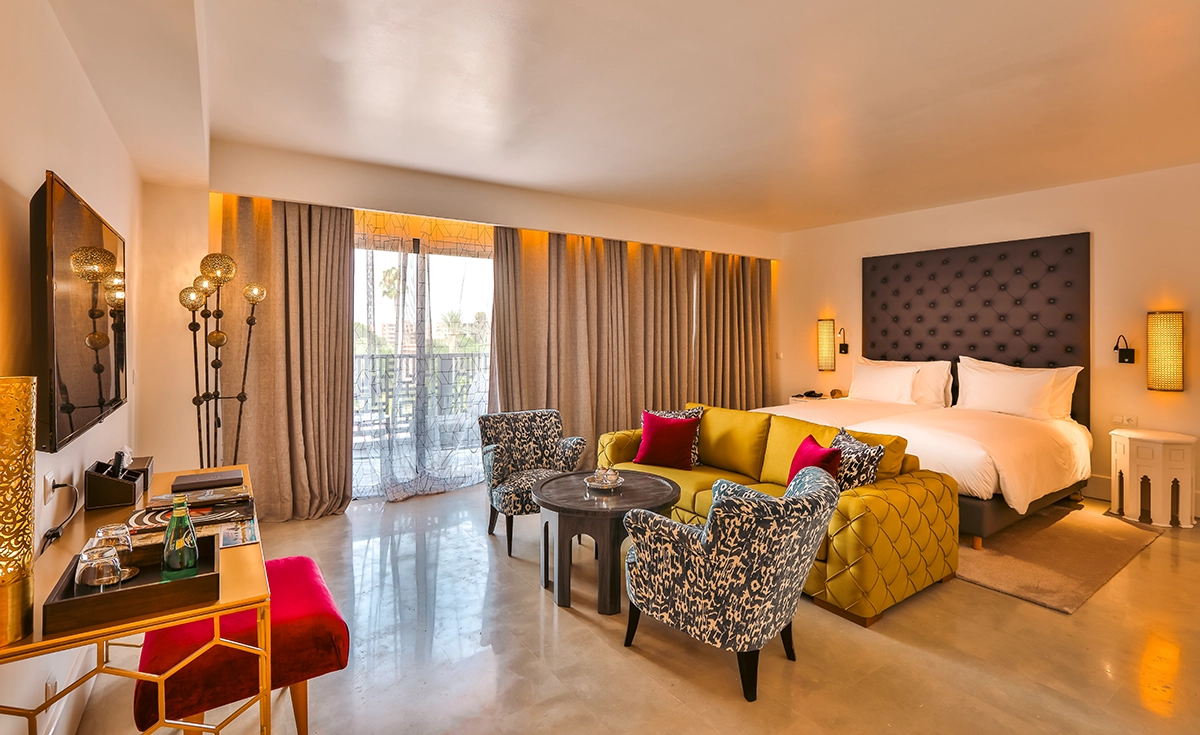 Salón de la Suite Prestige del hotel 2Ciels Marrakech con sofá y vistas al jardín